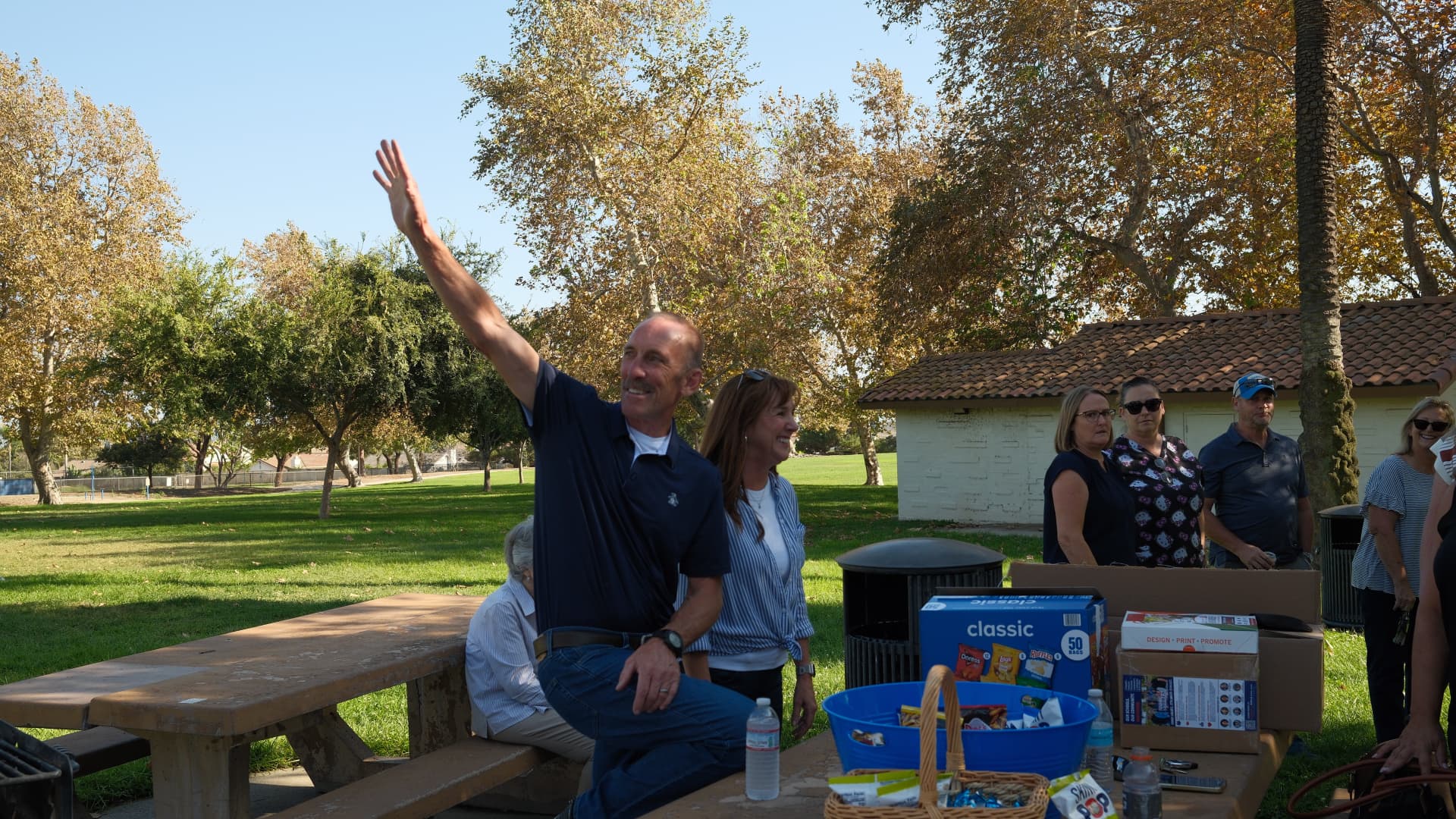 Art Andres waving to neighbors at a community gathering in the park