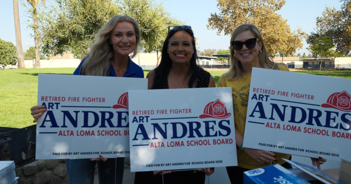 Three campaign volunteers holding Art Andres school board signs